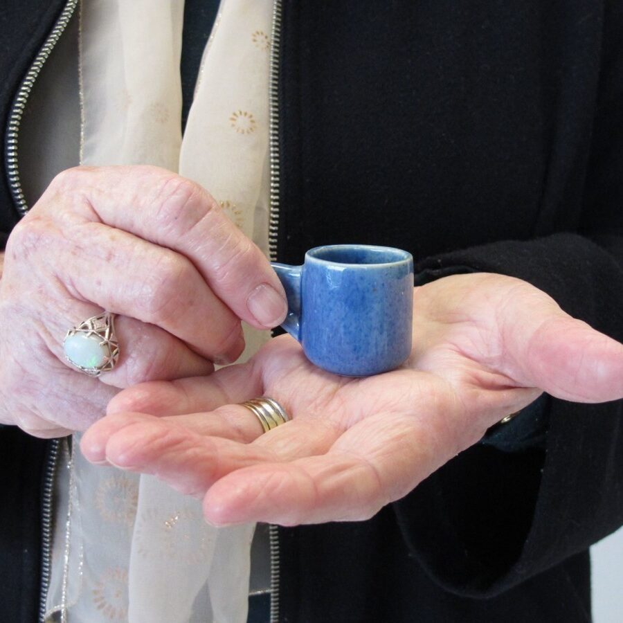 Marion Potbury in August 2016, holding a teacup she received in 1946